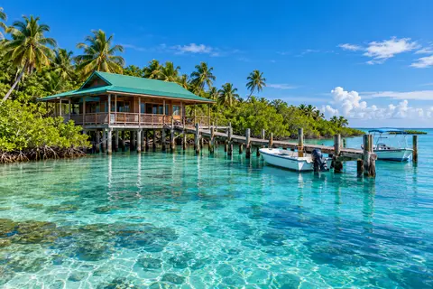 A small island inn on stilts with a dock over shallow turquoise water at Cabbage Key